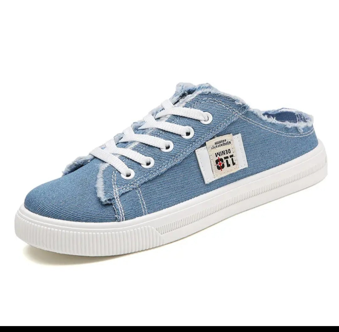 A single light blue denim slip-on canvas sneaker with white laces, a frayed hem, and a white rubber sole, shown on a white background.