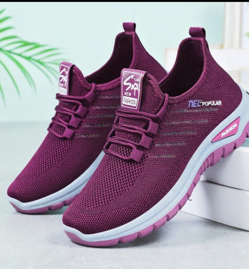 A pair of women's slip-on athletic sneakers in a deep plum purple color, featuring a breathable mesh upper, elastic lace closure, and a white and purple sole. The brand 'NEETUPULAR' is visible on the side of the shoe.